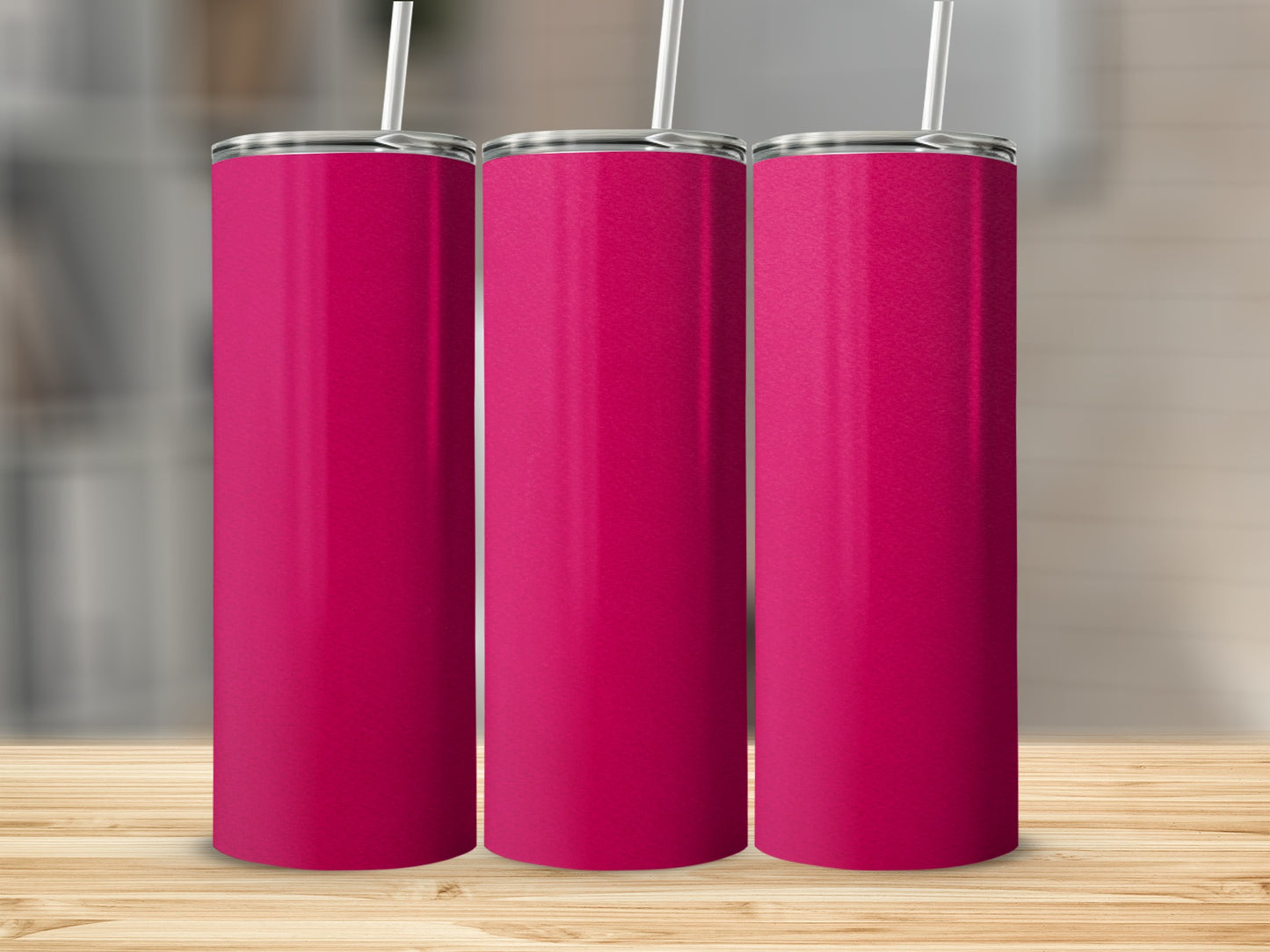 Three tall, pink tumblers with straws stand on a wooden surface.