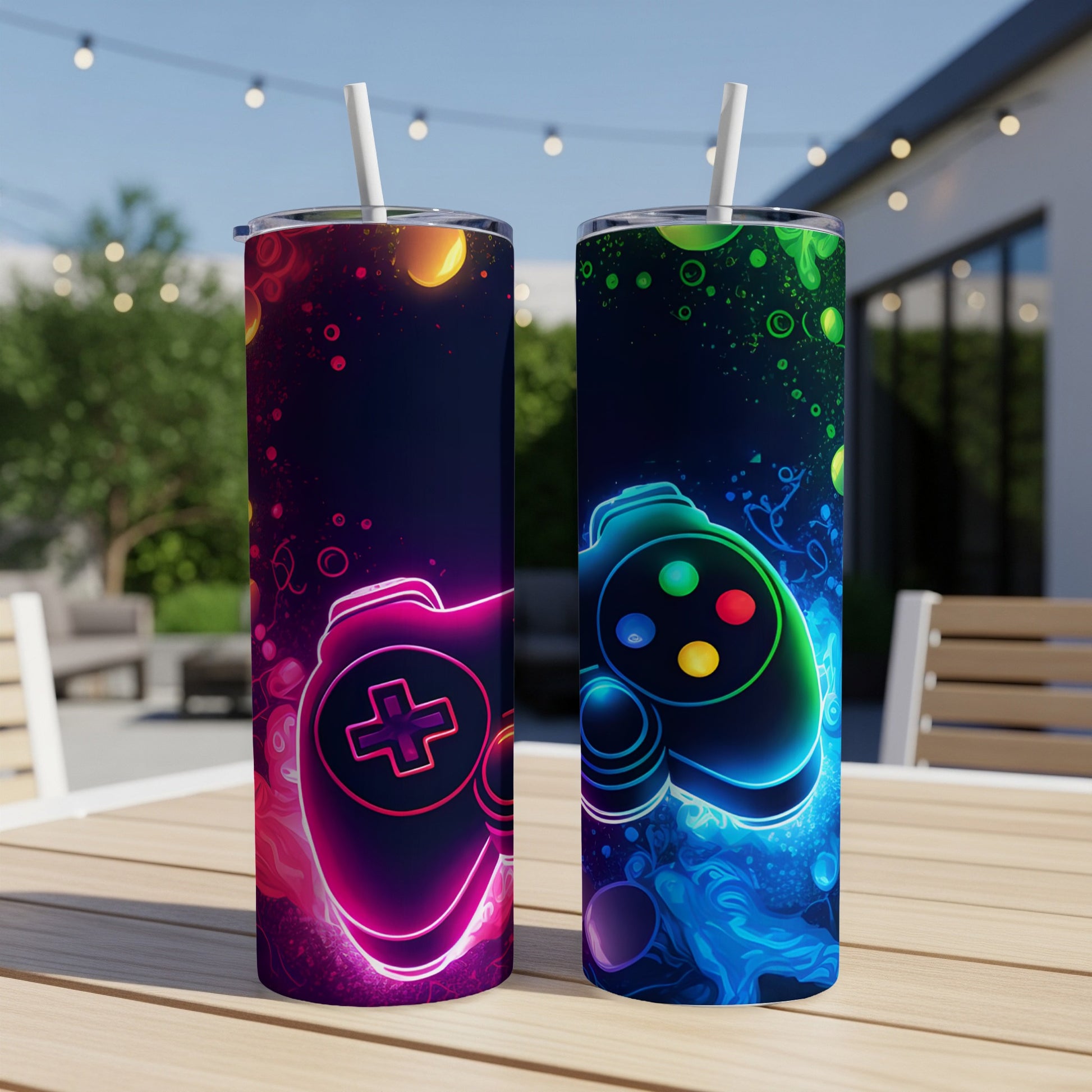 Two tumblers with neon gaming controller designs on outdoor table.