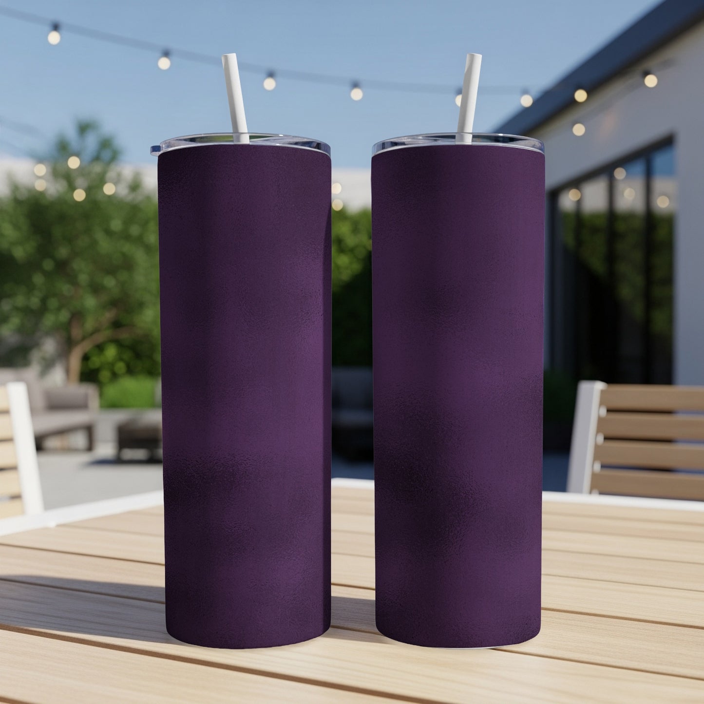 Two purple tumblers with white straws stand on a wooden table outdoors.
