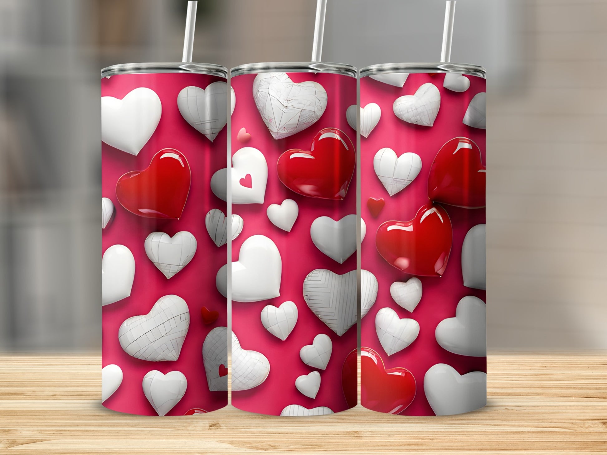 Three tumblers with red and white heart designs on a pink background.