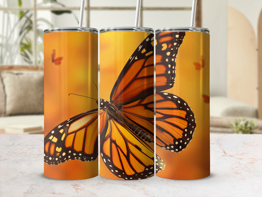 Orange monarch butterfly tumblers with colorful butterfly background.