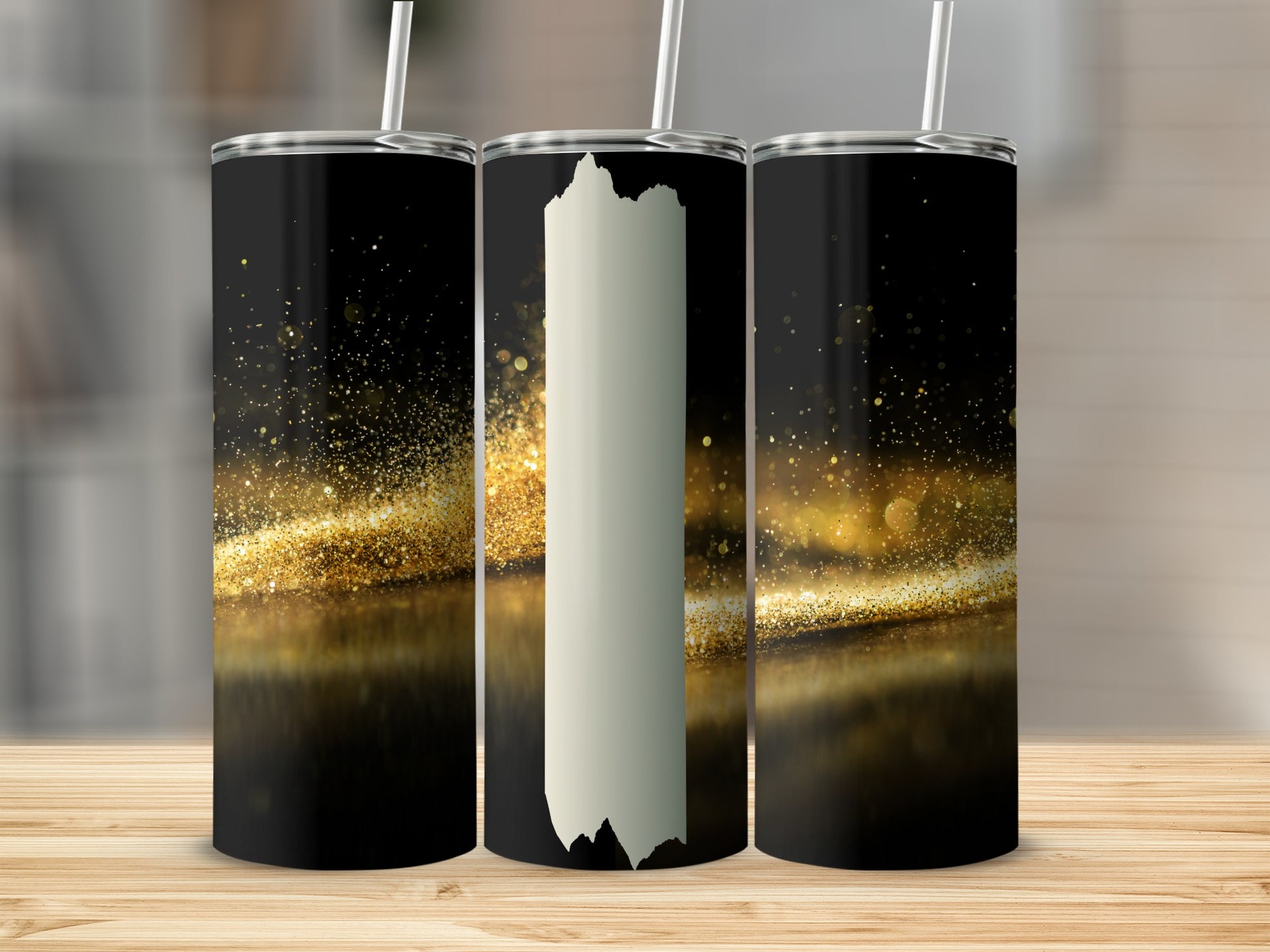 Three tumblers with gold glitter and black backgrounds displayed on a wooden surface.