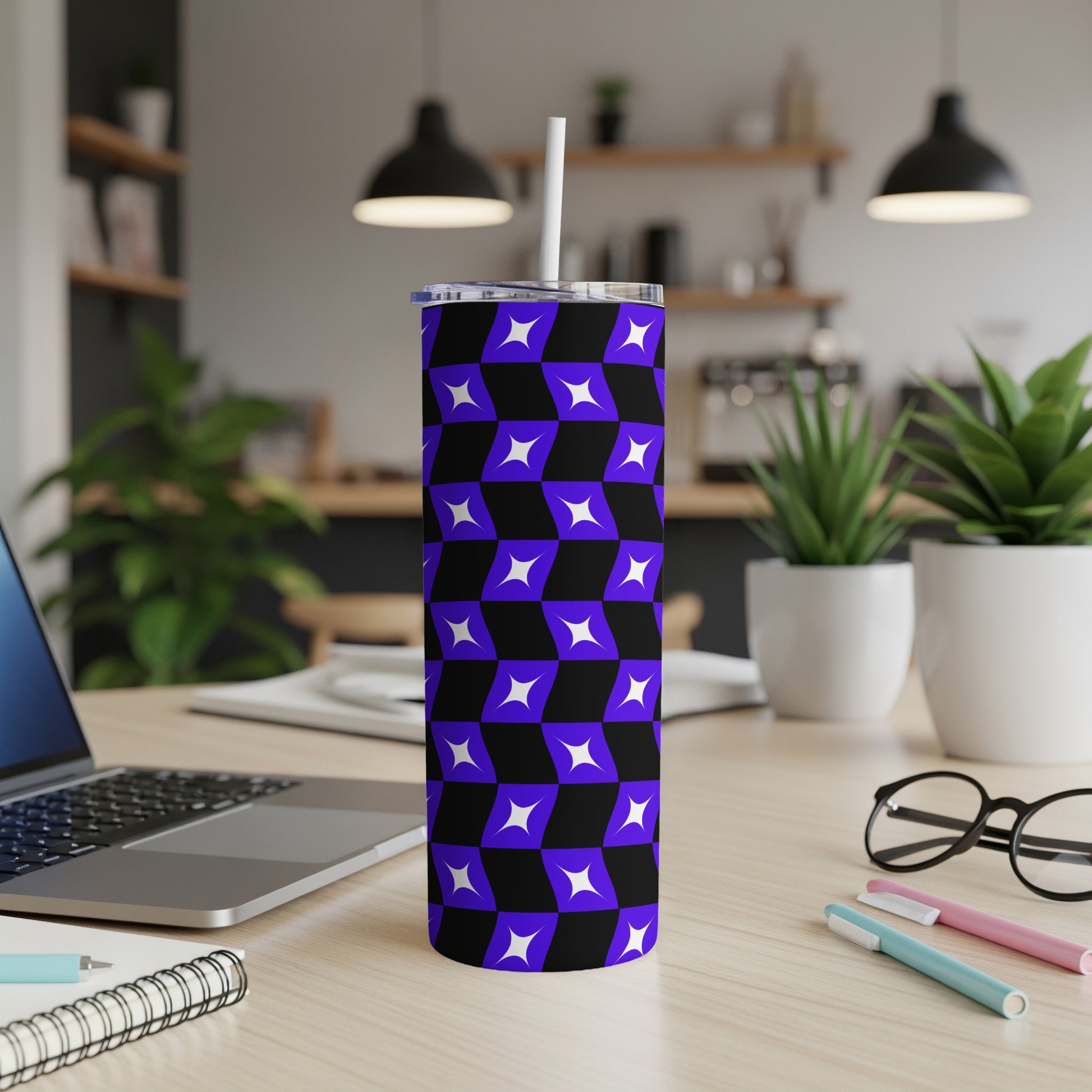 Purple and blue geometric tumbler with straw on a desk.