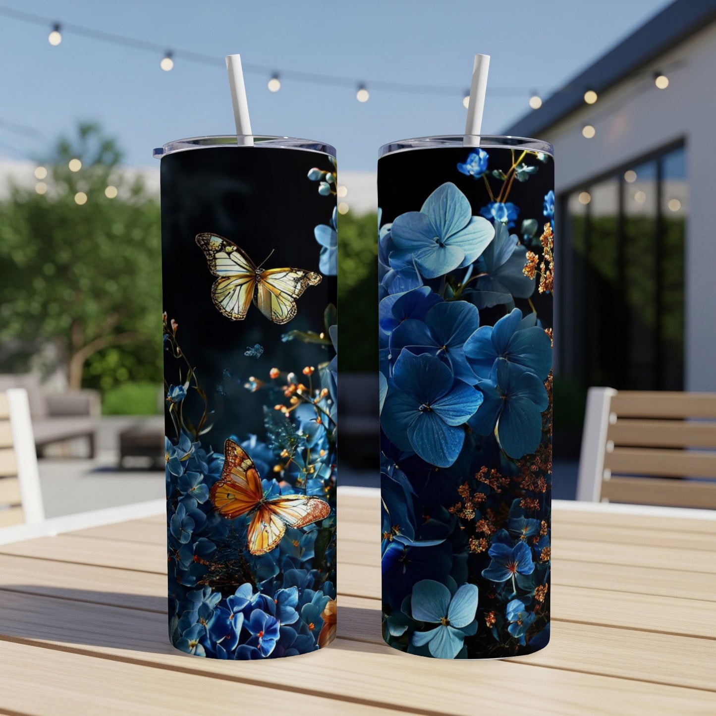 Two tumblers with blue hydrangea and butterfly designs on a table.