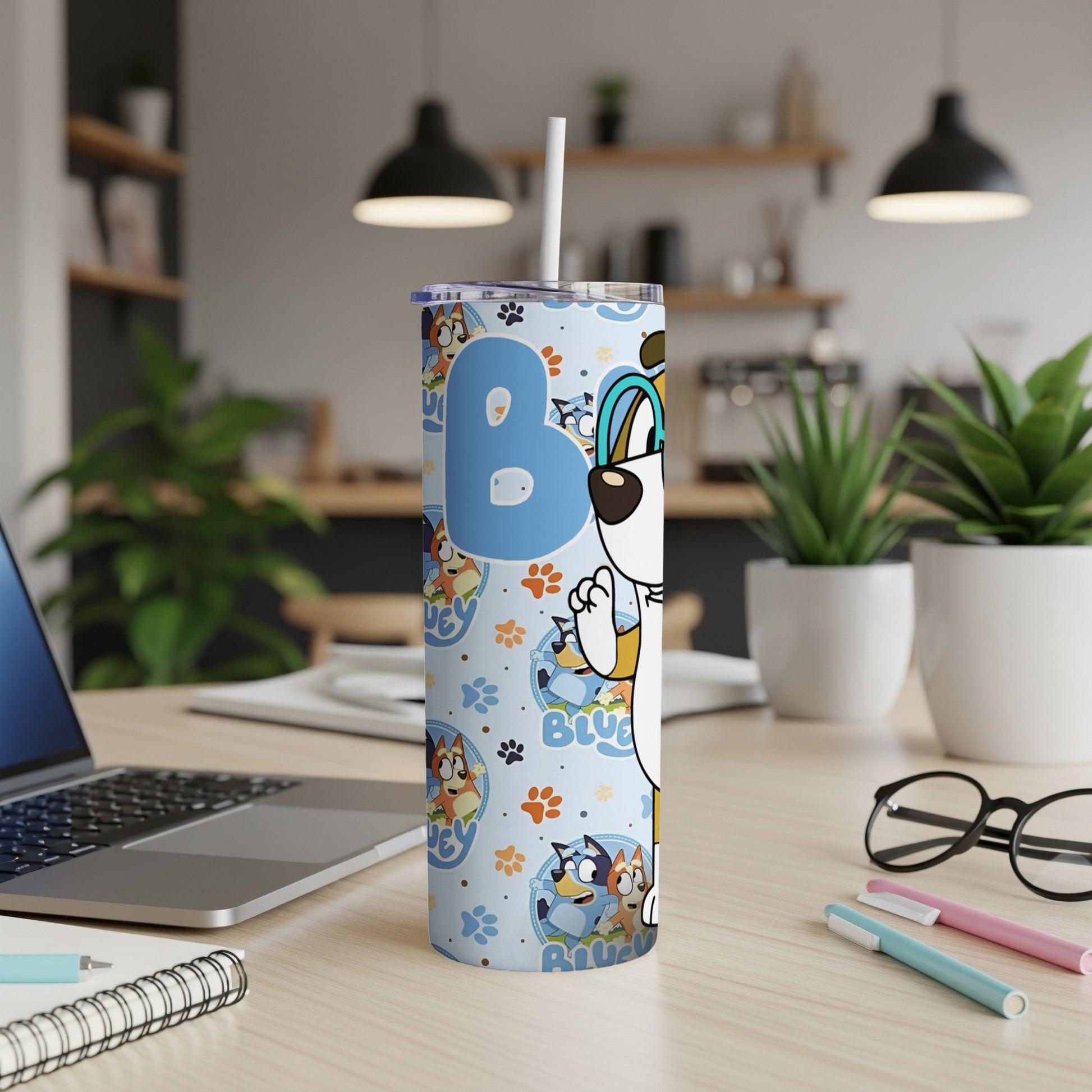 Bluey character art on a blue tumbler with cartoon dogs and a straw.