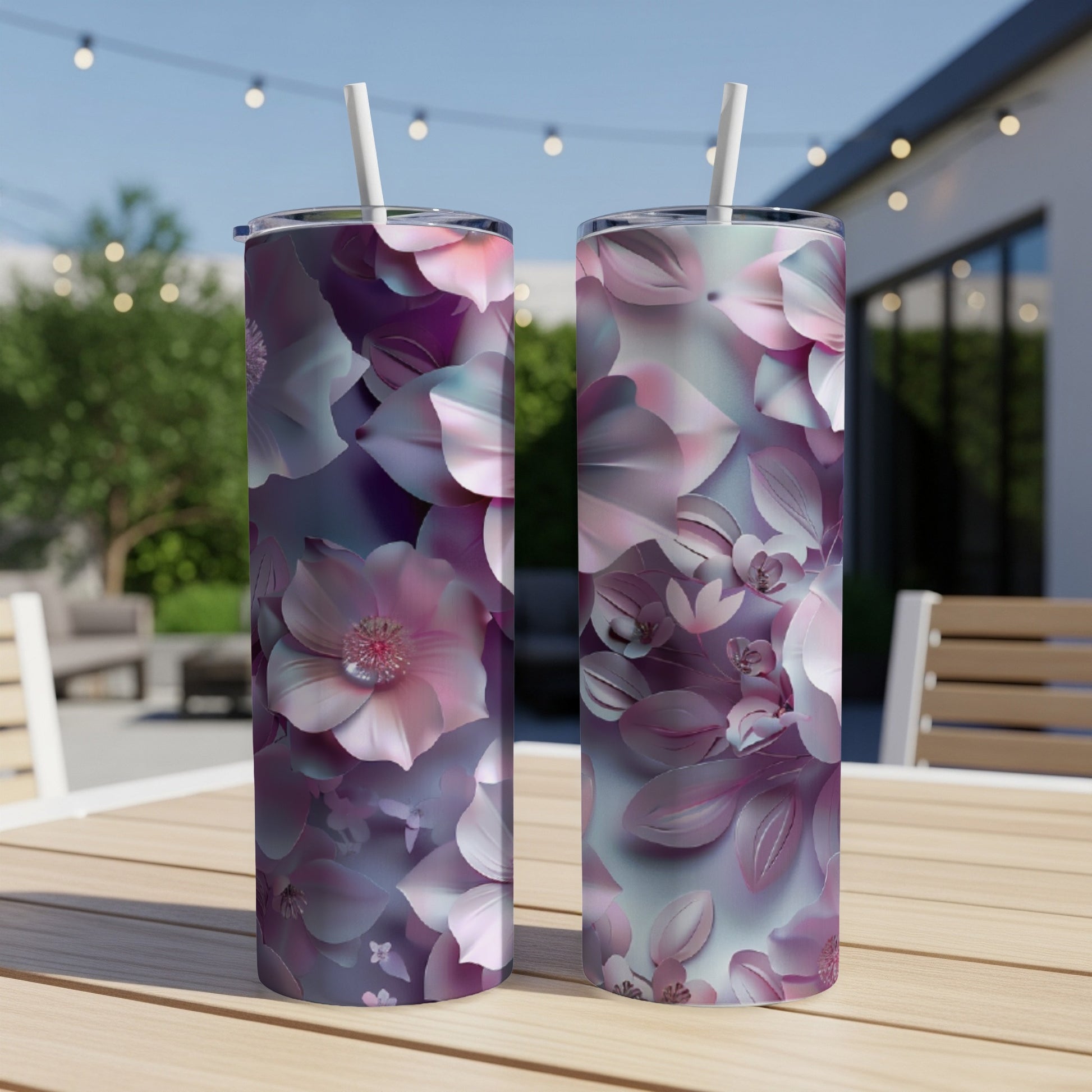 Two tall tumblers with a pink and purple floral design on a wooden table.