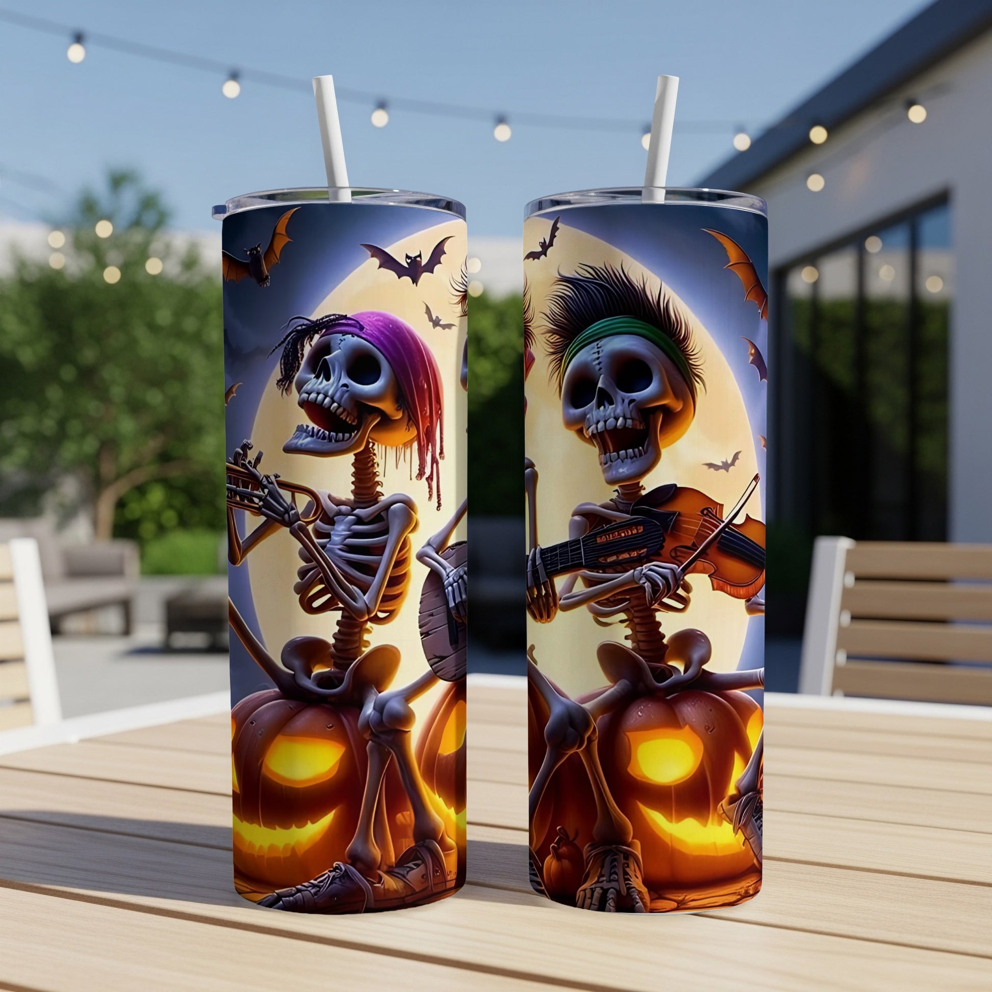Two tumblers featuring skeletons playing instruments beside pumpkins under a moonlit sky.