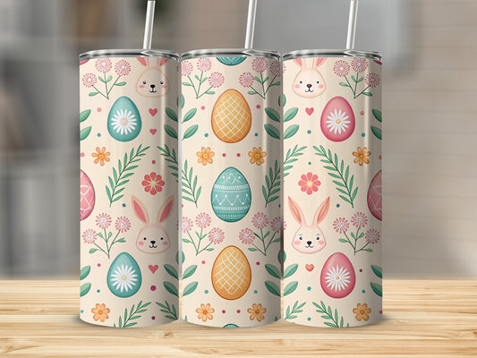 Three Easter-themed tumblers with bunny, egg, and floral patterns on a wooden surface.