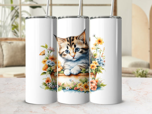 Kitten in floral basket on a white tumbler.