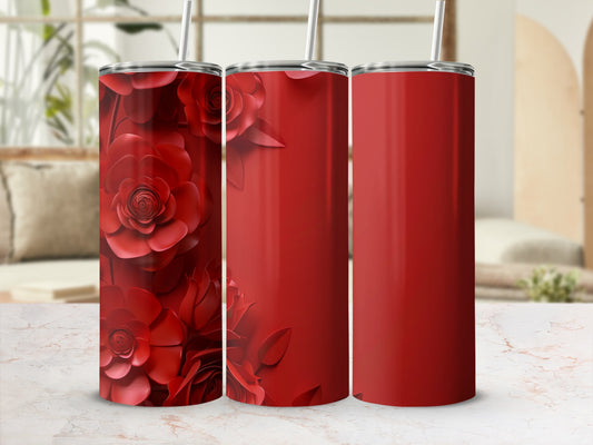 Red floral patterned tumbler next to two solid red tumblers.