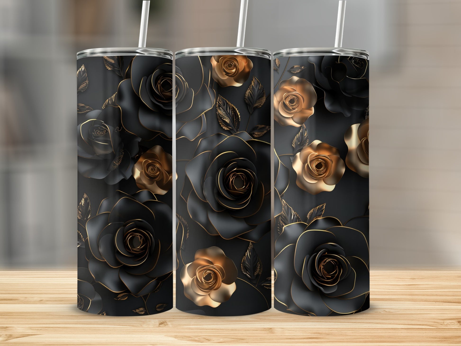 Three black tumblers with gold rose floral design on a wooden surface.