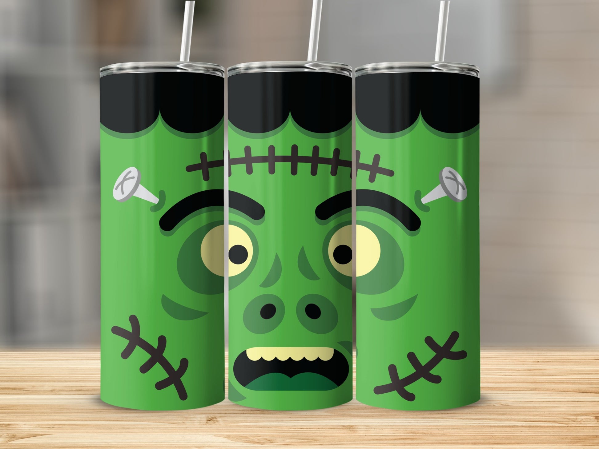 Three green tumblers with Frankenstein faces and straws.