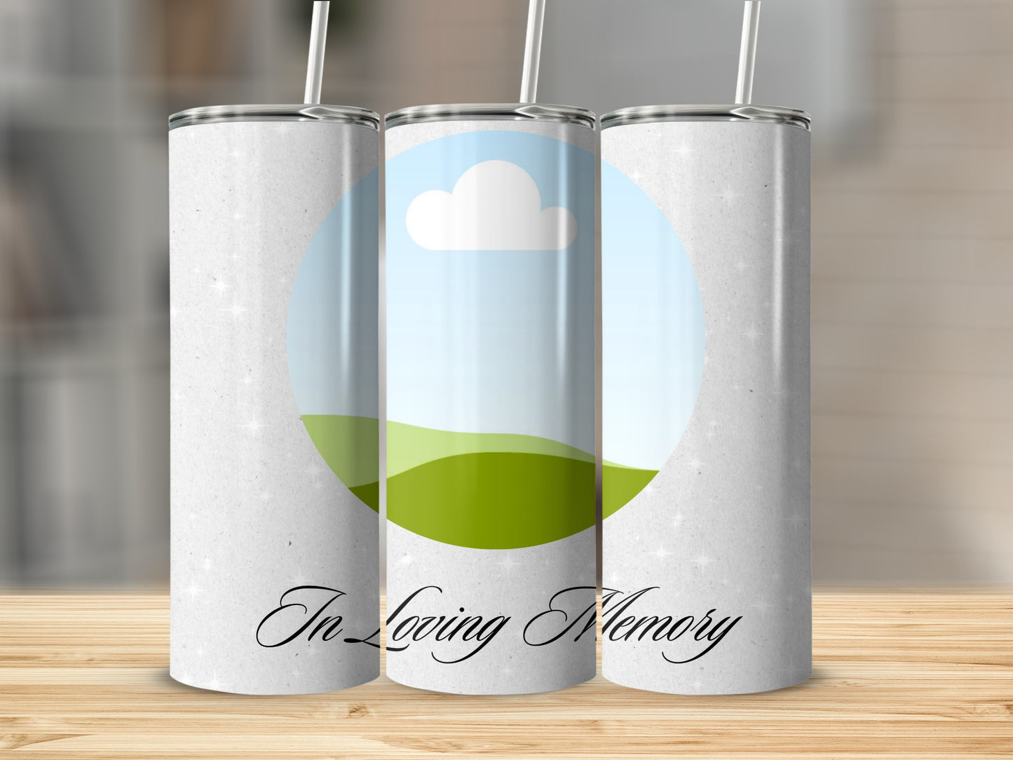 Three tumblers with a sky, cloud, and green hill design, with "In Loving Memory" text.