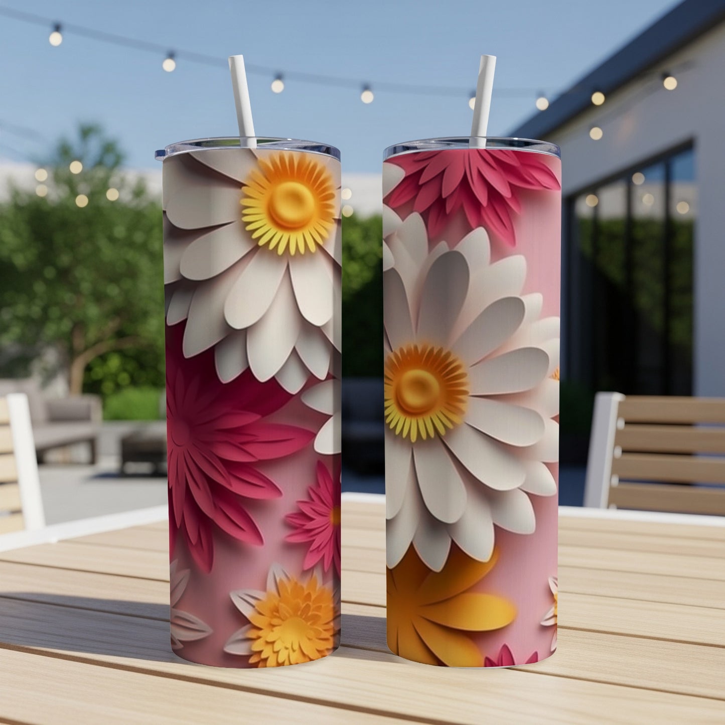 Two tall tumblers with layered daisy floral designs on a table.