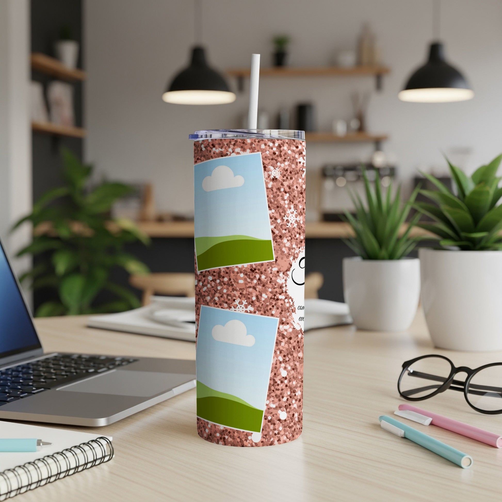 Glitter tumbler with two photo frames and a straw on a desk.
