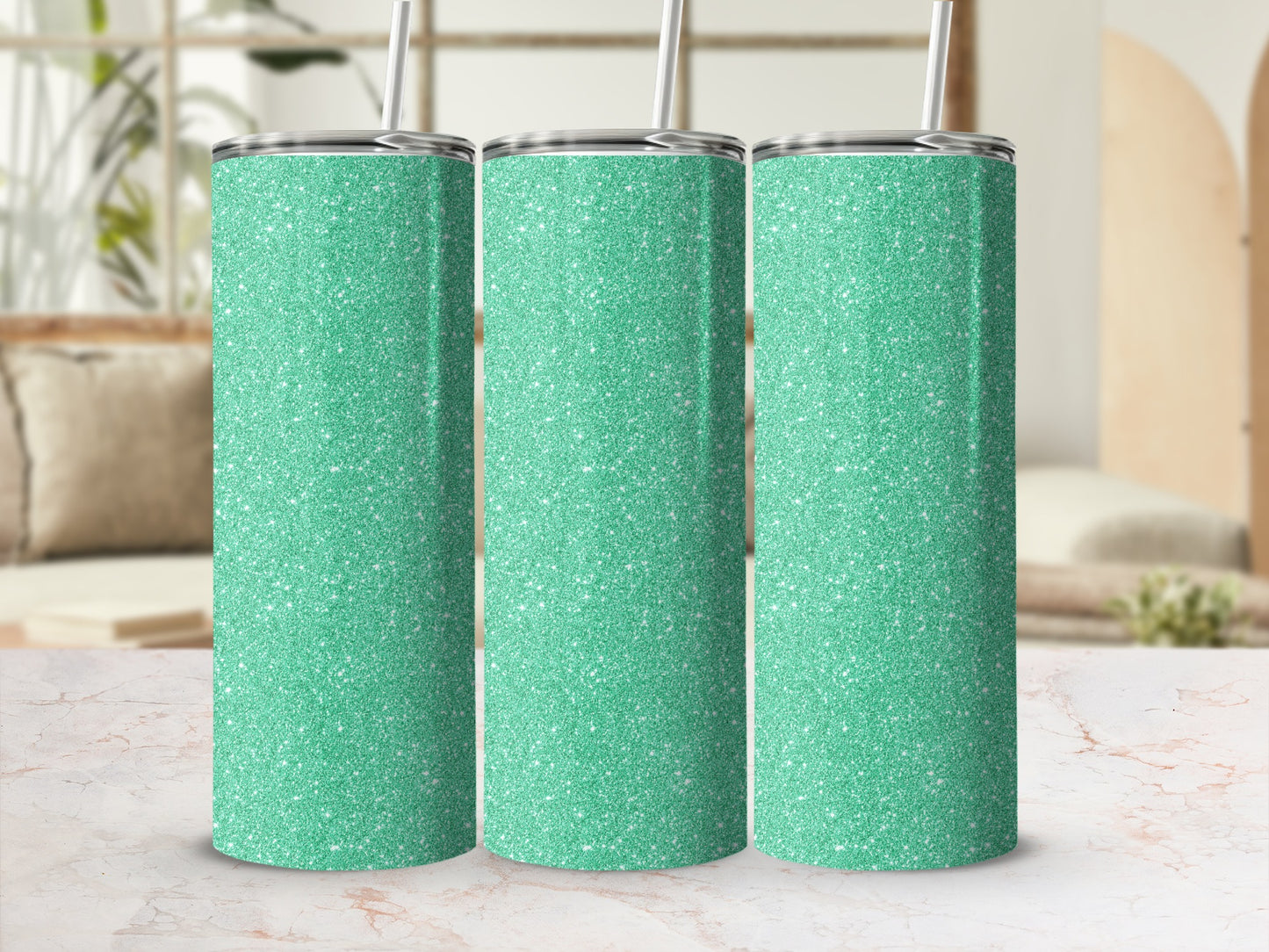 Three glittery seafoam green tumblers with straws stand side-by-side.