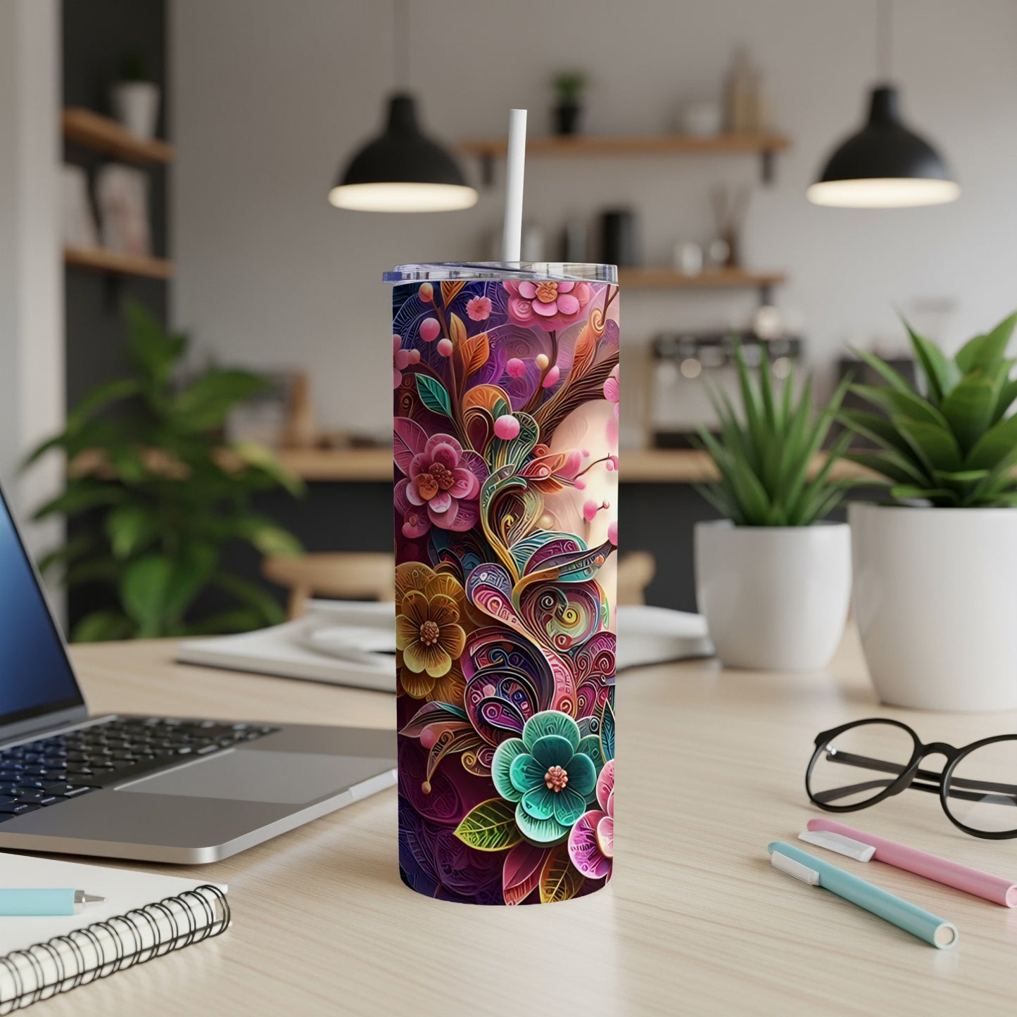 Floral patterned tumbler with a straw on a desk.