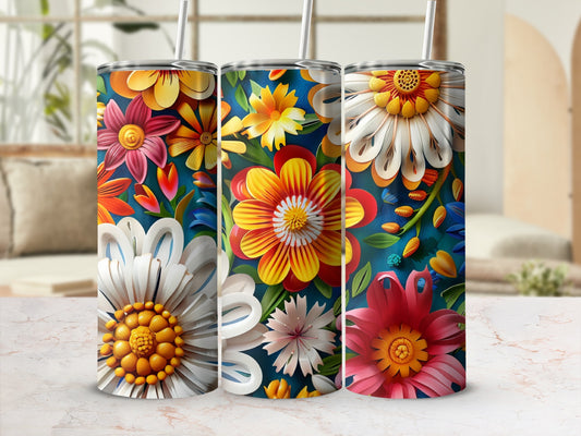Three tumblers with colorful floral designs on a marble surface.
