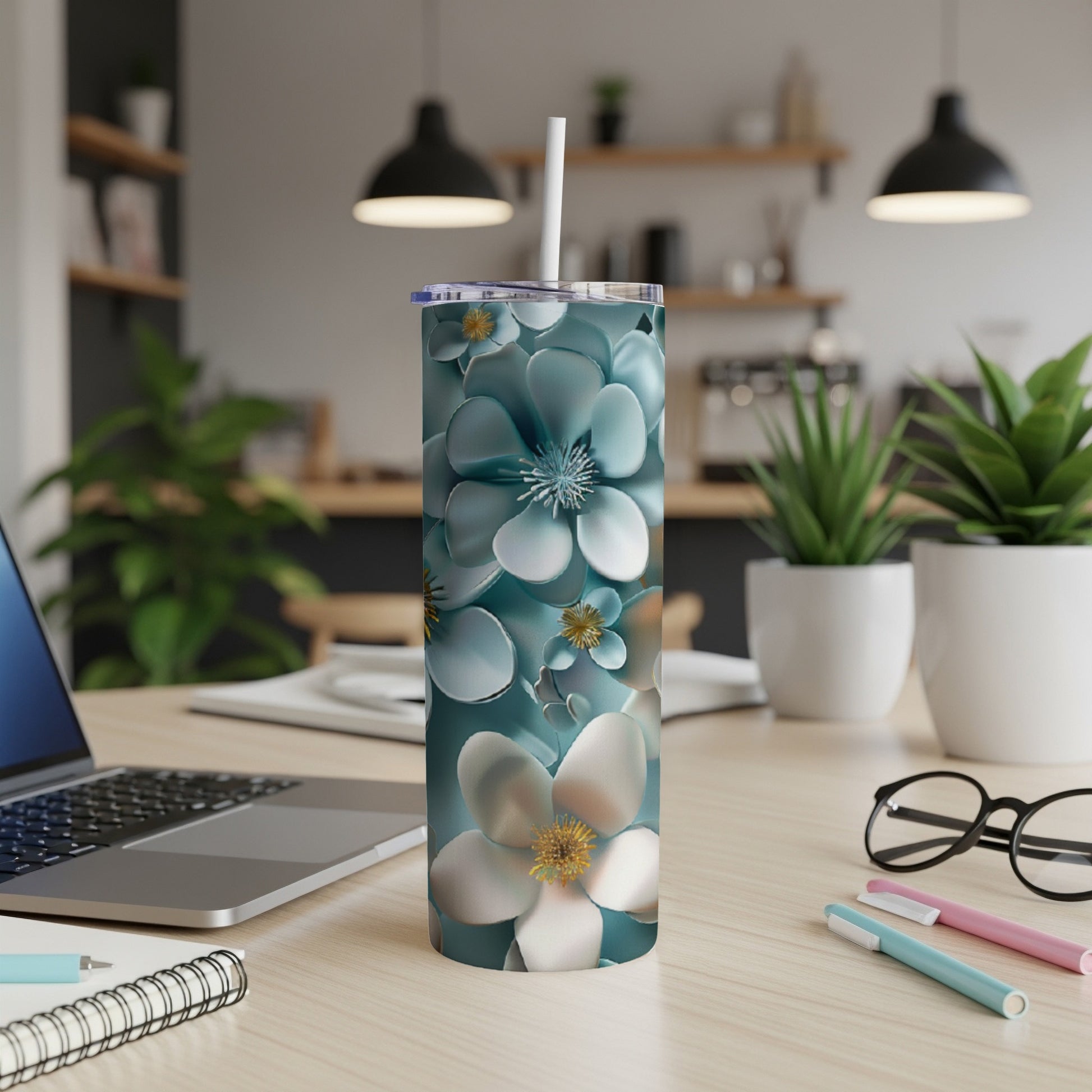 White and blue floral tumbler with straw on a desk.