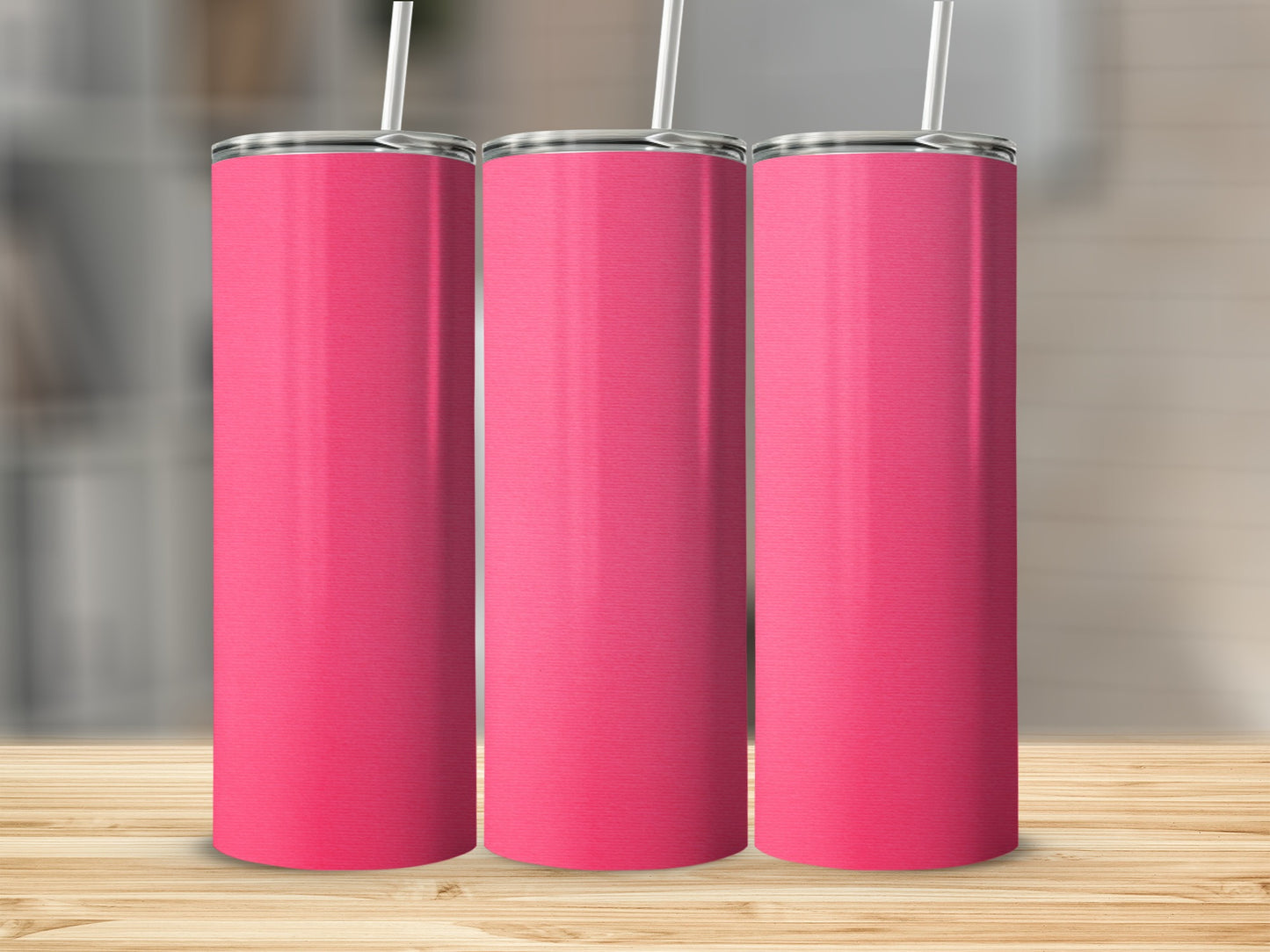 Three pink tumblers with white straws on a wooden surface.