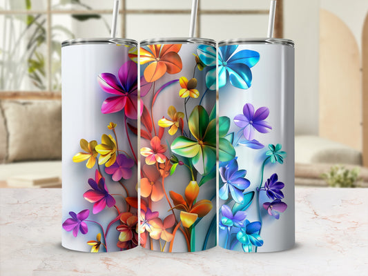 Three colorful floral tumblers with straws on a marble surface.