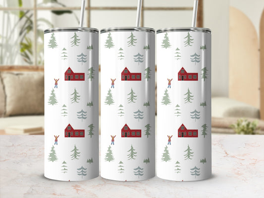 White tumbler with repeating pattern of red houses, evergreen trees, and people.