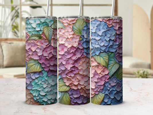 Three tumblers with colorful hydrangea floral patterns and straws.
