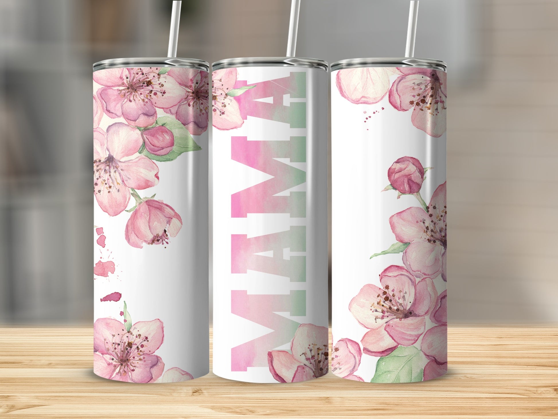 Pink floral Mama tumbler with straw on a wooden surface.