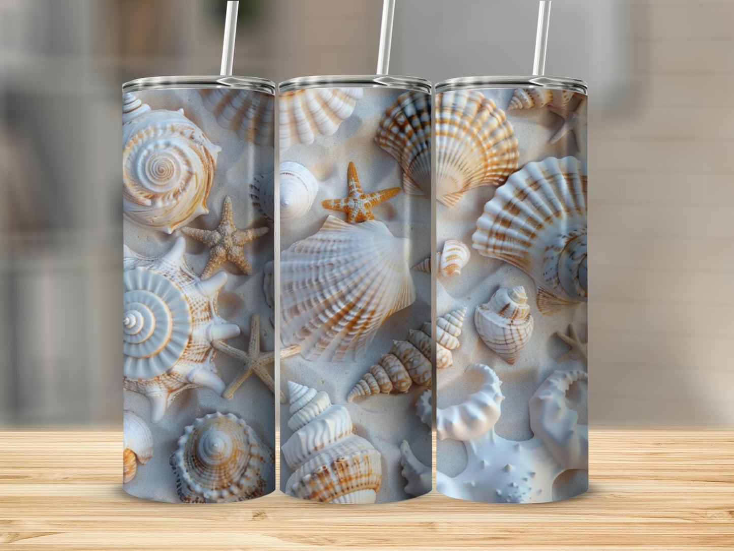 Three tumblers with a beach shell pattern displayed on a wooden surface.