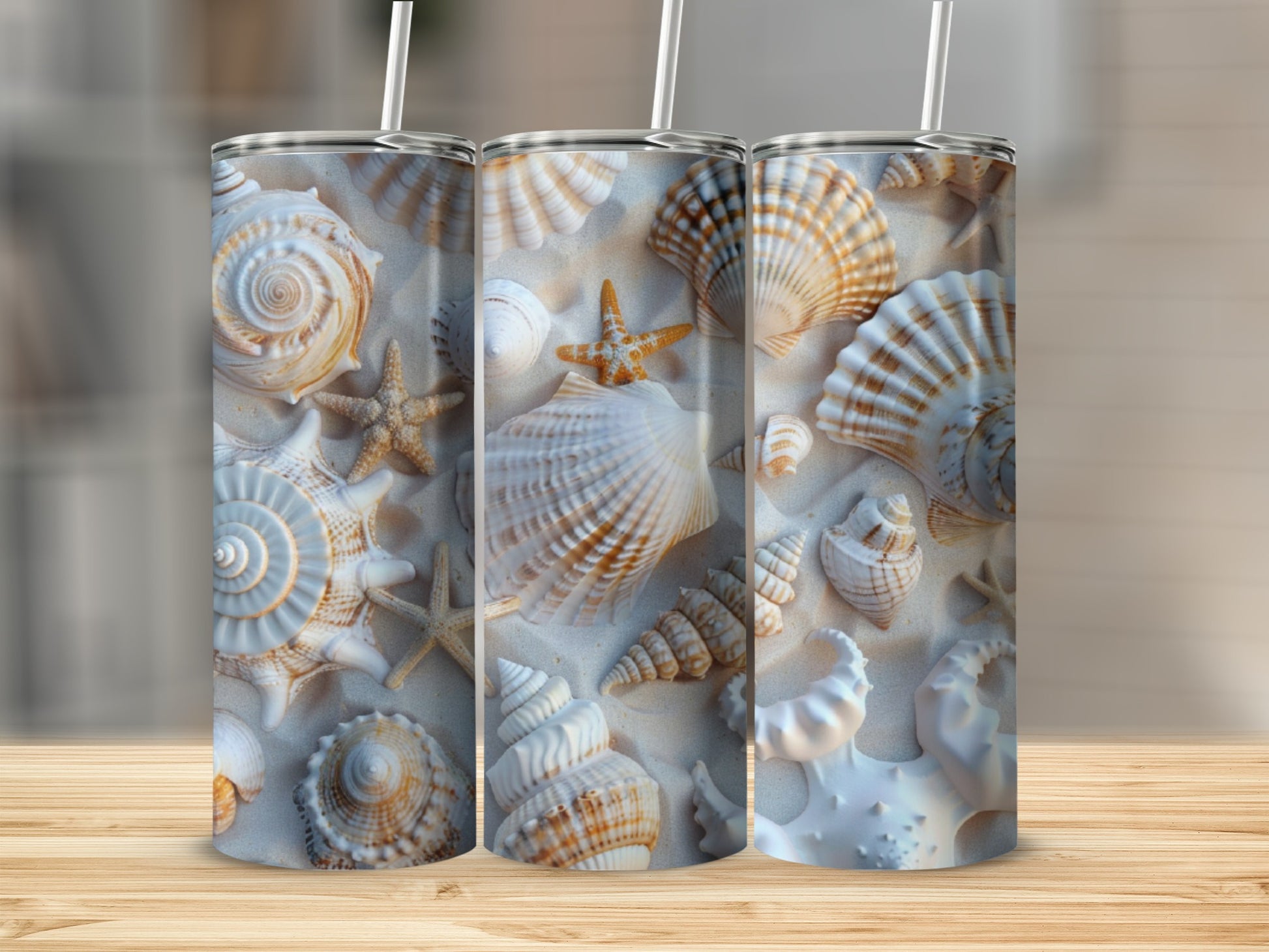 Three tumblers with a beach shell pattern displayed on a wooden surface.