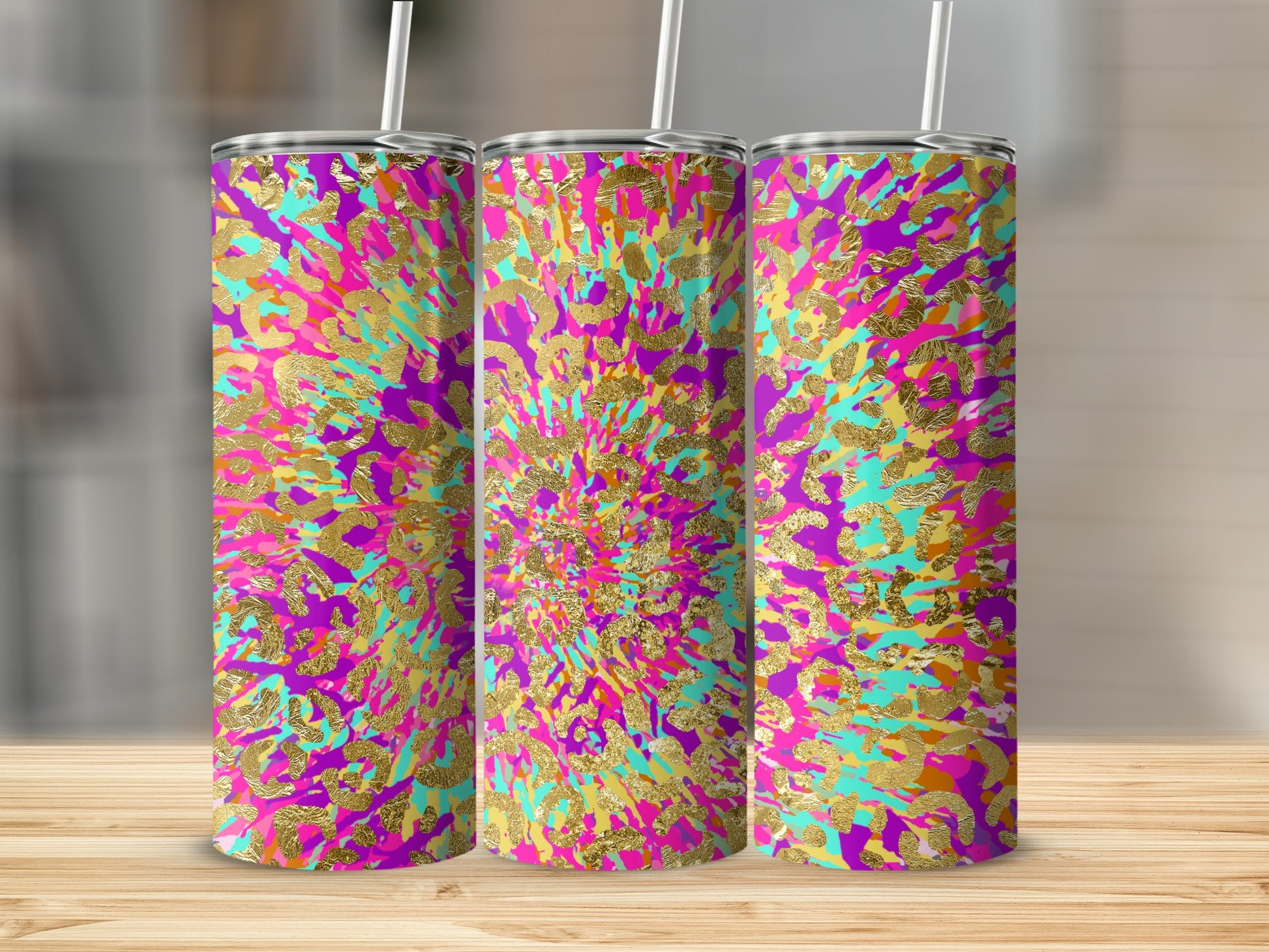 Three skinny tumblers with vibrant tie-dye and gold leopard print pattern.