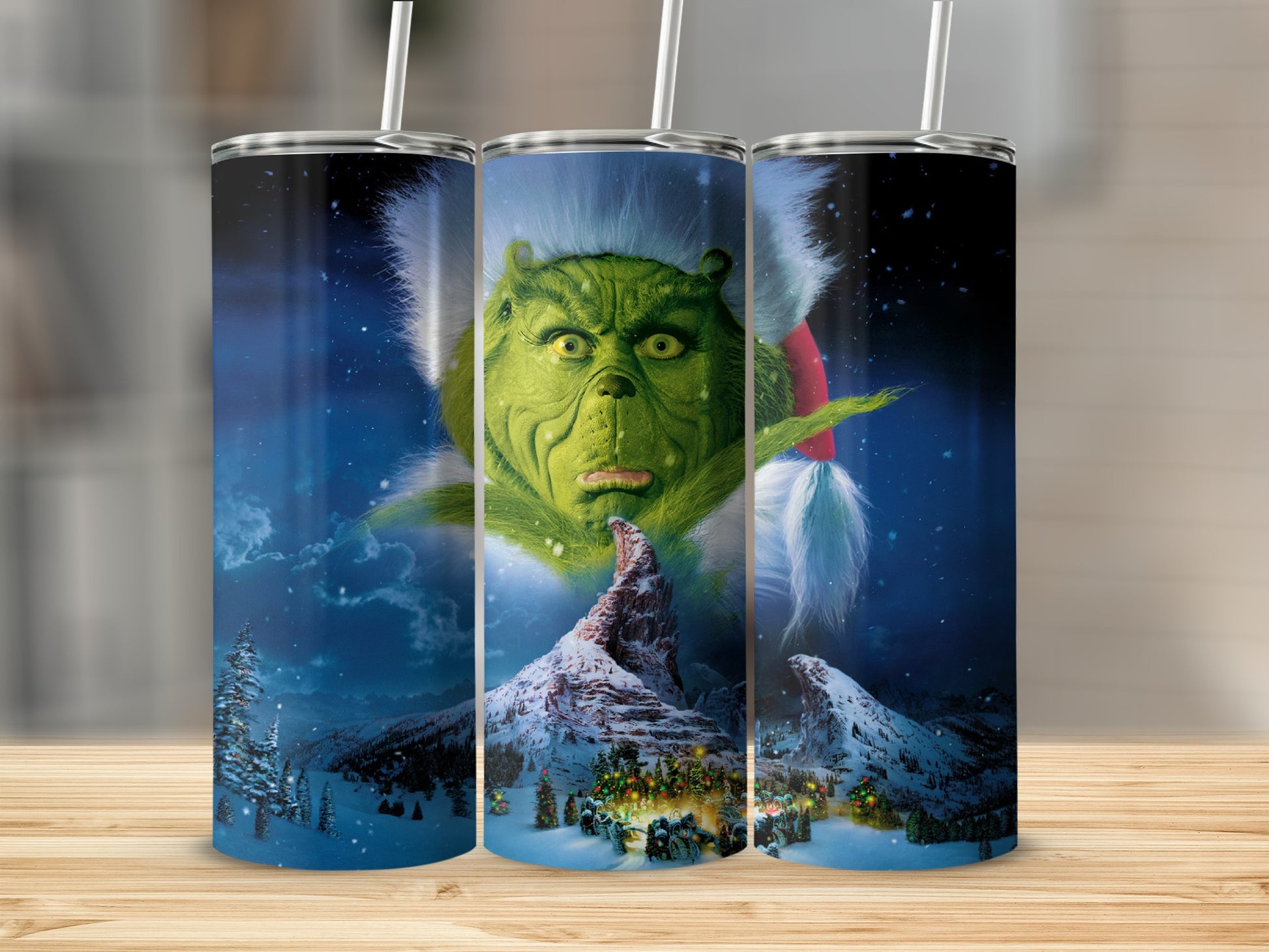 The Grinch is shown on a tumbler with a snowy mountain village.