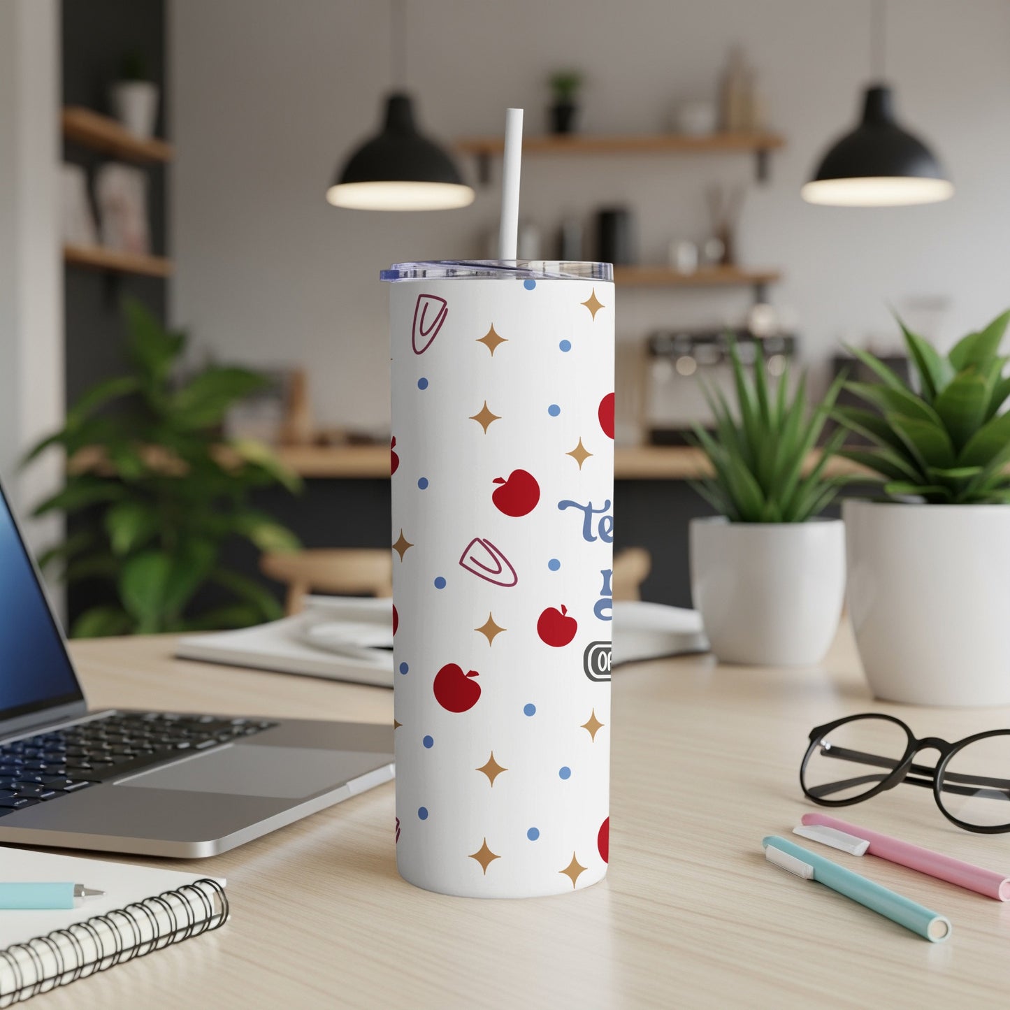 White tumbler with apple and paperclip pattern, "Teach Love Inspire" text.