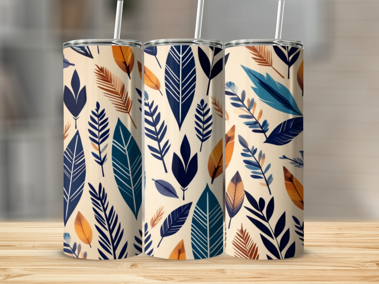 Three tumblers with a repeating pattern of cream, navy, teal, and rust-colored leaves.