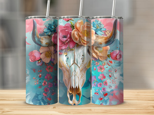 Floral bull skull tumbler with straws on a wooden surface.