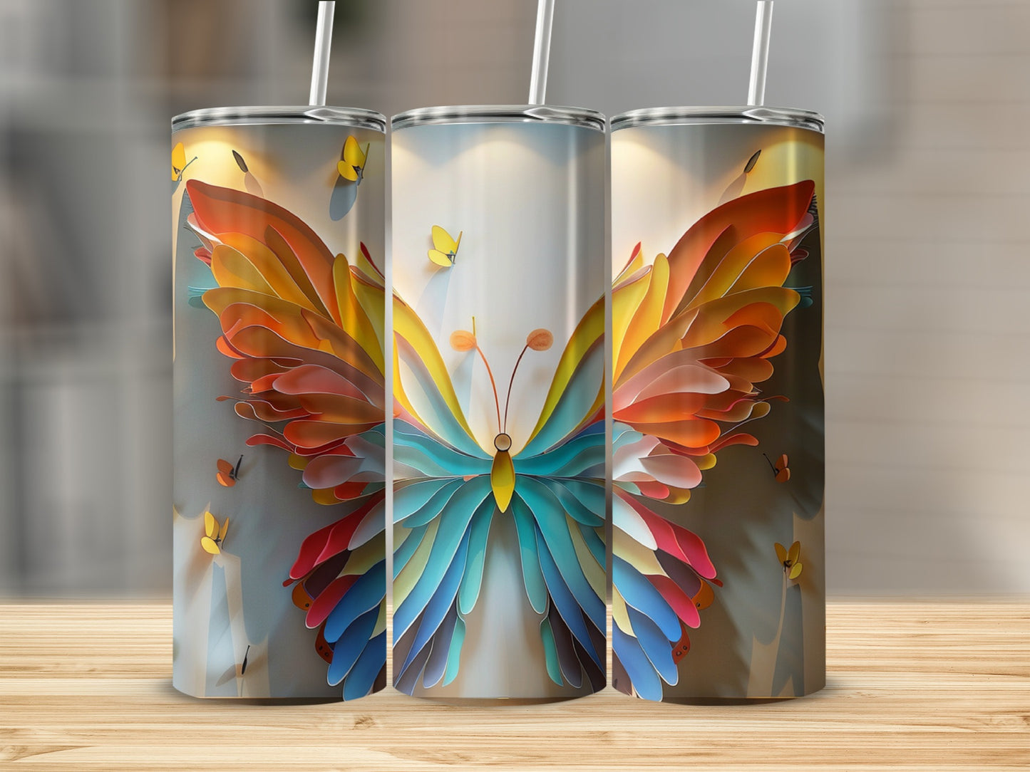 Three tumblers with a colorful butterfly design on a wooden surface.