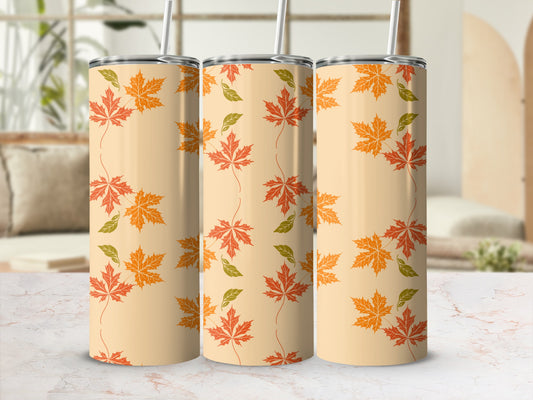Beige tumbler with repeating pattern of orange and green maple leaves.
