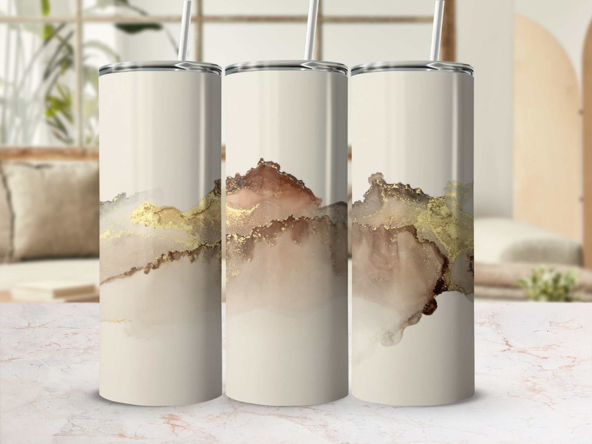 Three cream tumblers with abstract gold and brown watercolor designs.