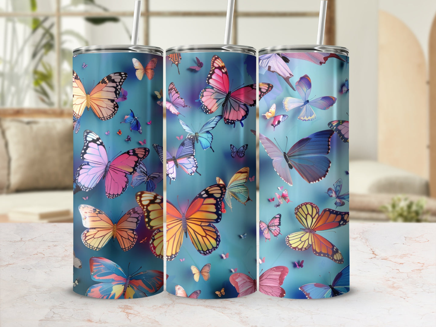 Three tumblers with colorful butterflies against a blue background.