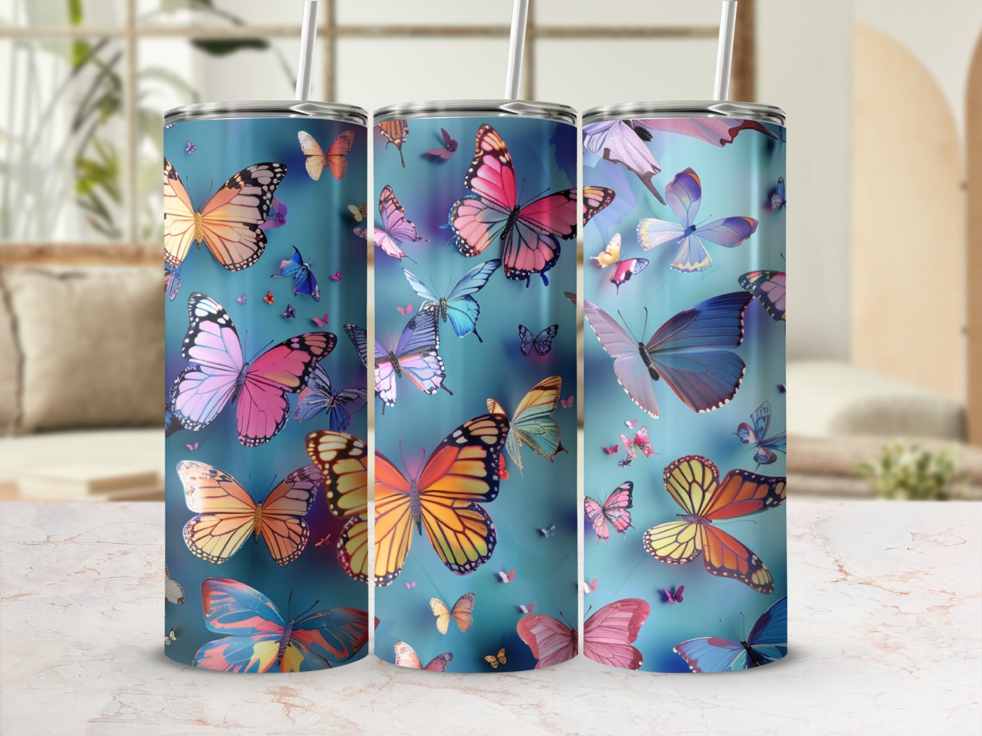 Three tumblers with colorful butterflies against a blue background.