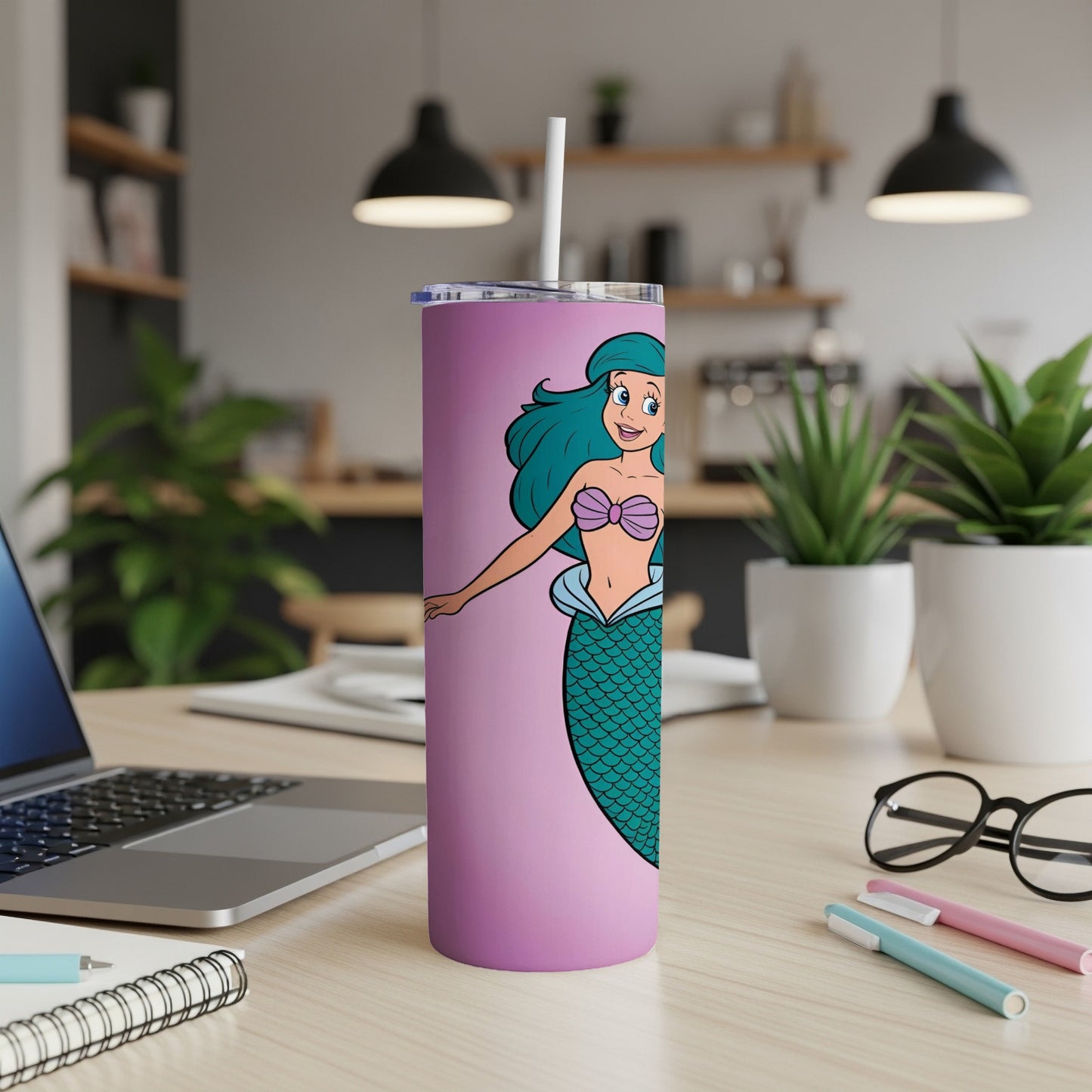 Pink tumbler with cartoon mermaid design and straw.