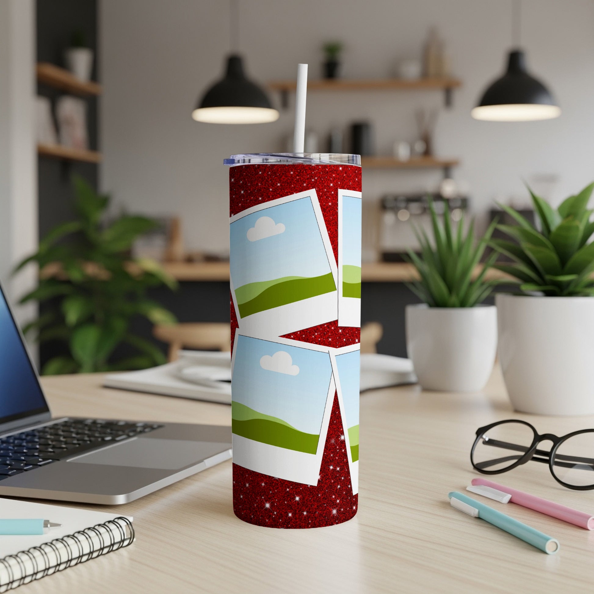 Red glitter tumbler with scattered photos of landscape scenes and a white straw.