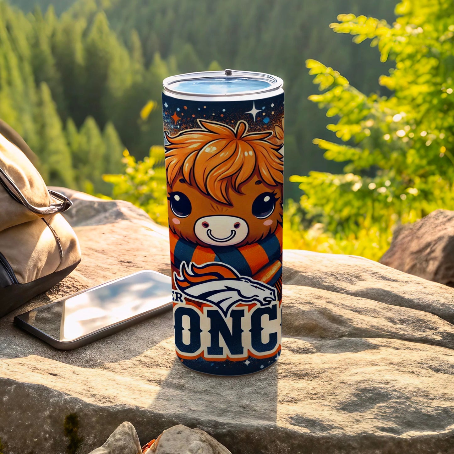 Denver Broncos tumbler with cartoon mascot on a rock outdoors.