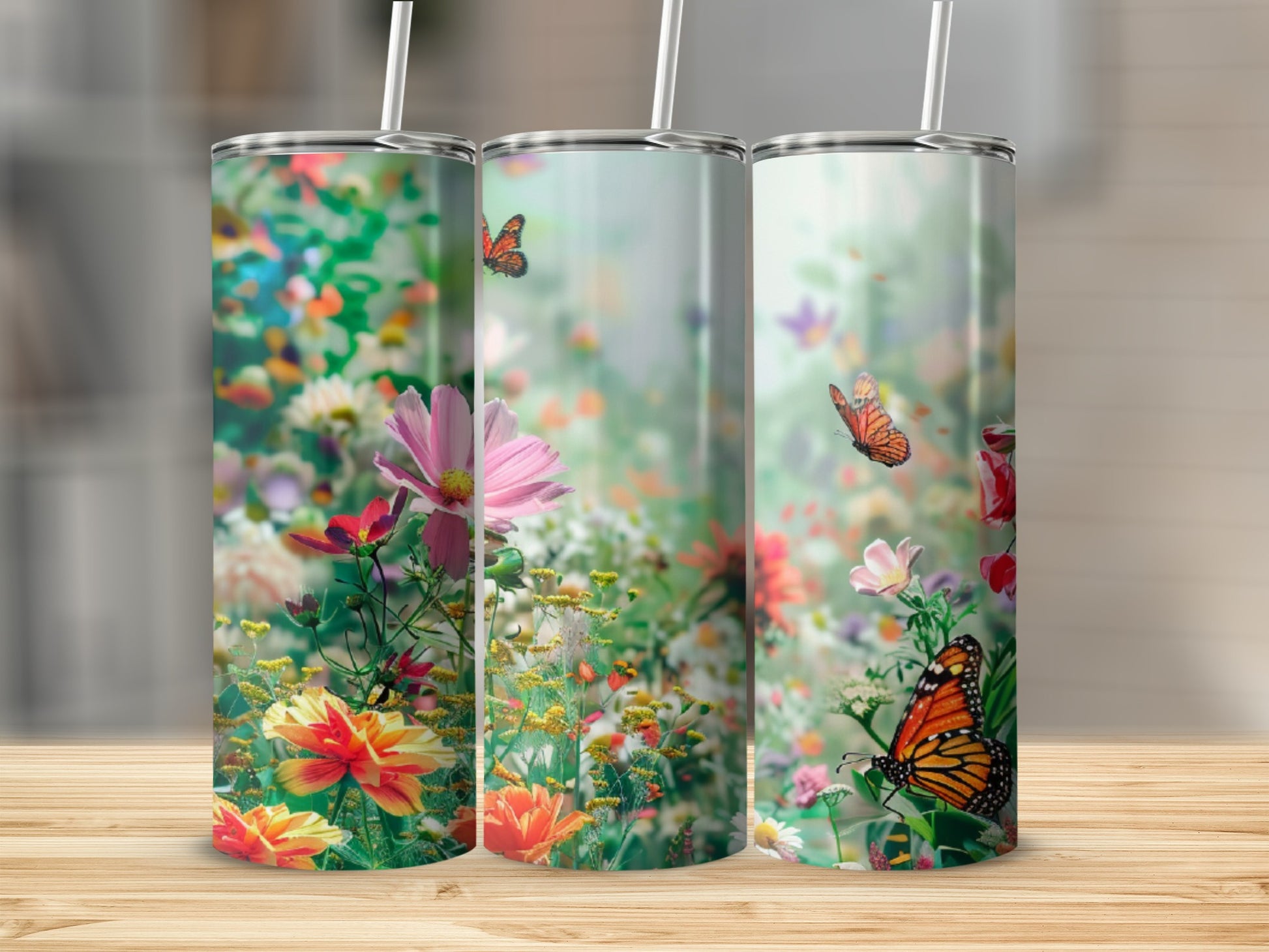 Three tumblers with a vibrant floral and butterfly design.