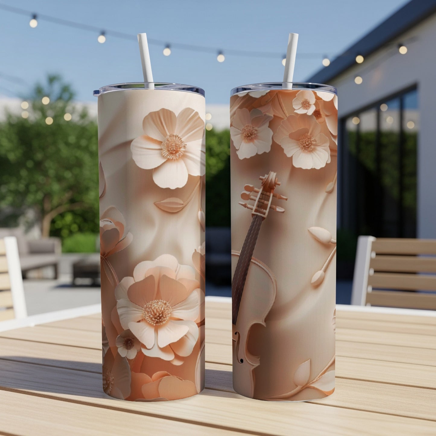 Two tall tumblers with floral and violin designs, on a table.