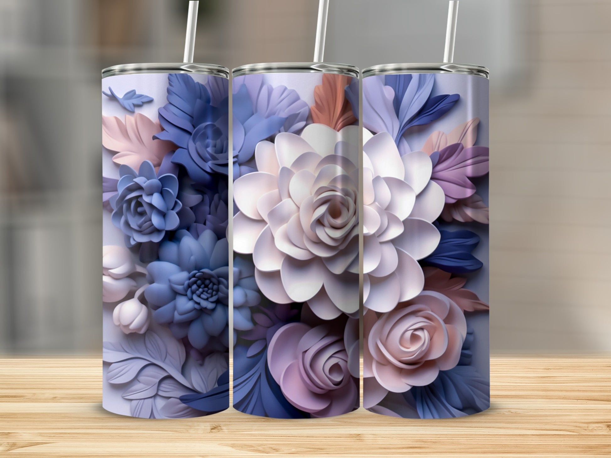 Three tumblers decorated with layered floral patterns in shades of blue, purple, and pink.