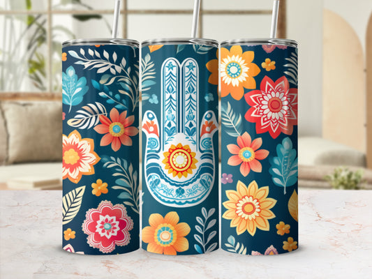 Three tumblers with a floral and hamsa hand pattern on a table.