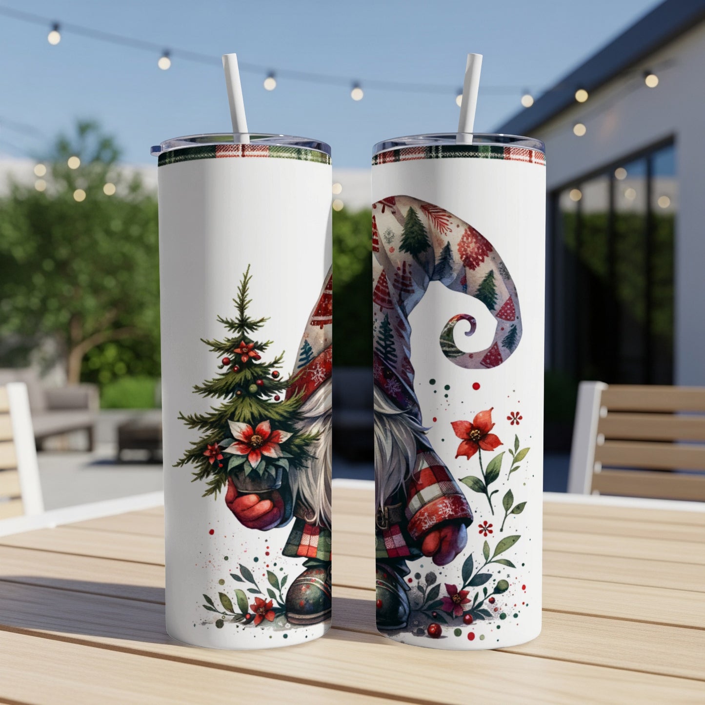 Two tumblers with a gnome and Christmas tree design sit on a table.