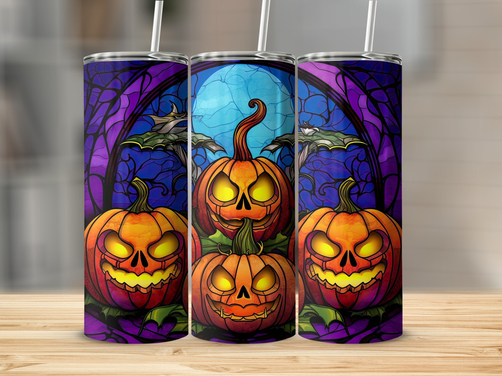 Three tumblers with jack-o'-lanterns and stained glass Halloween design.