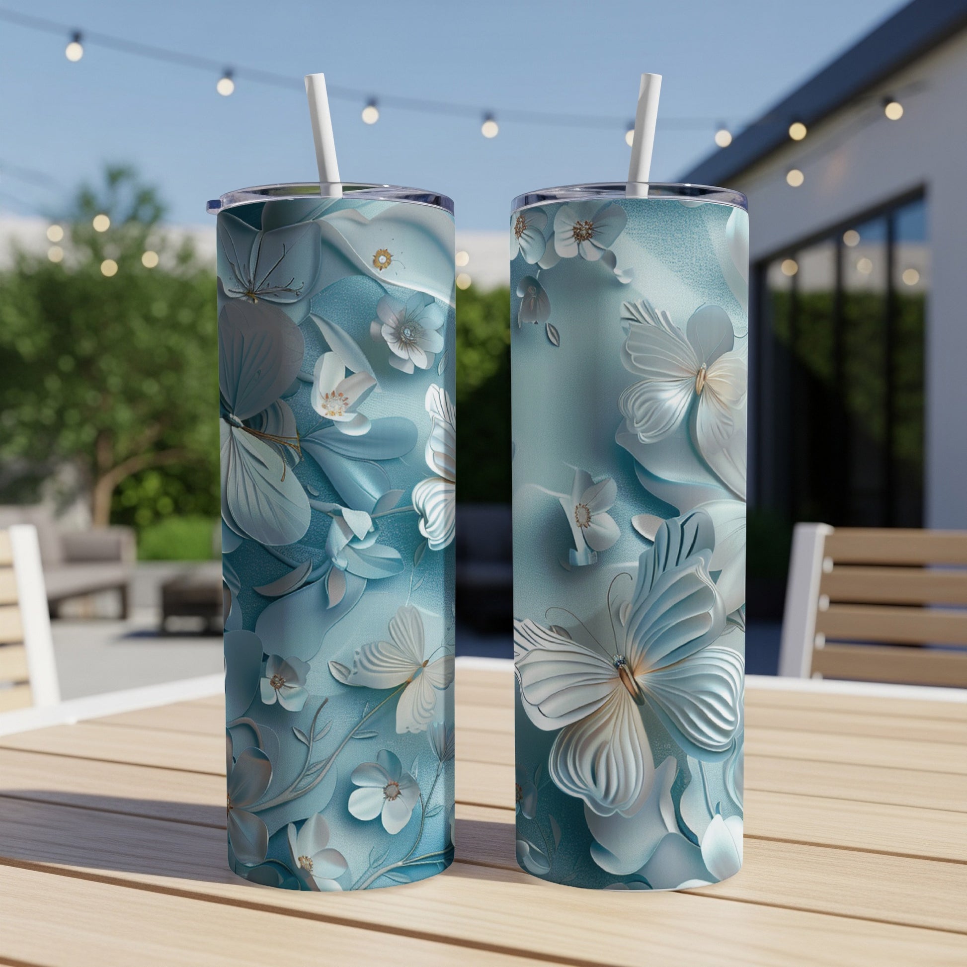 Two teal tumblers with raised white butterflies and floral designs.